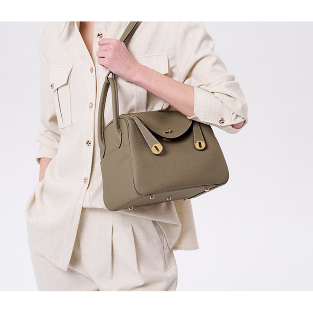 Sac à main bandoulière en cuir noir de la marque Élégance Cuir, avec poignée en métal doré et design élégant.