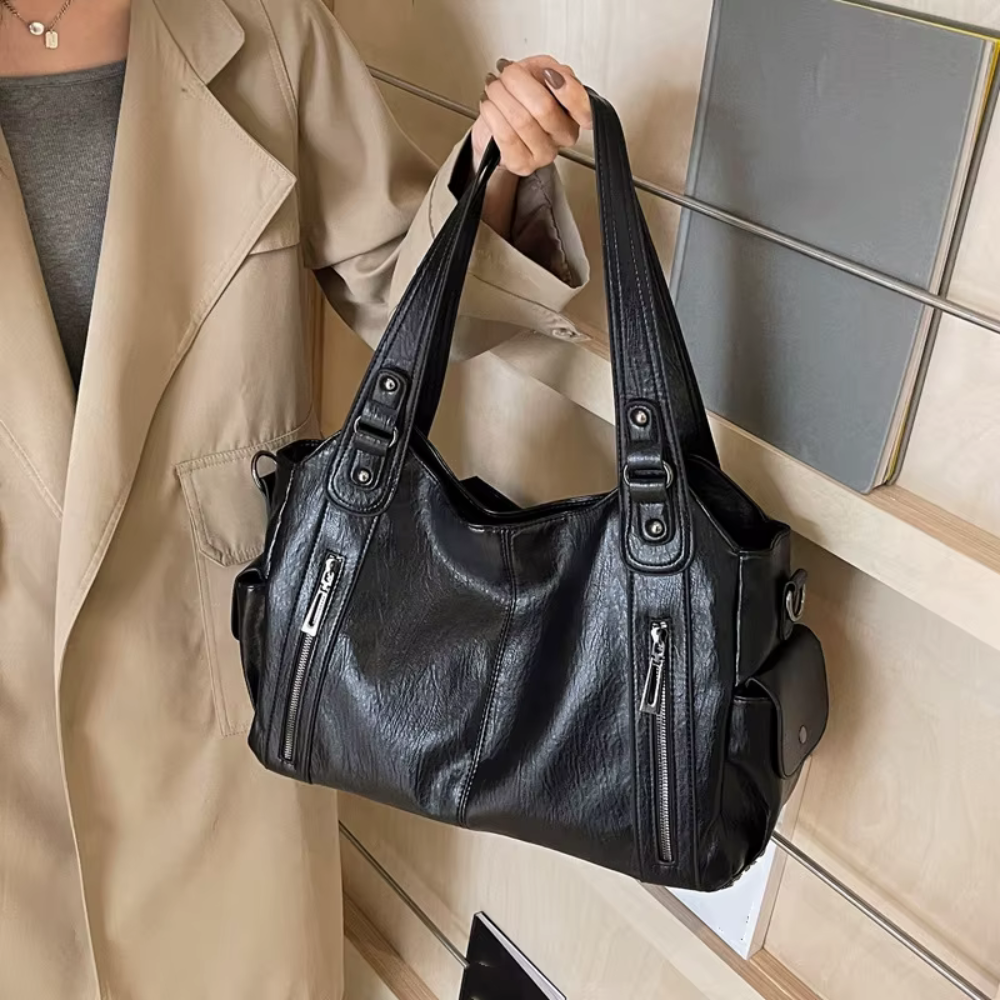 Sac à main souple Lucie de la marque Élégance Cuir, en cuir doux, avec poignées et compartiments visibles.