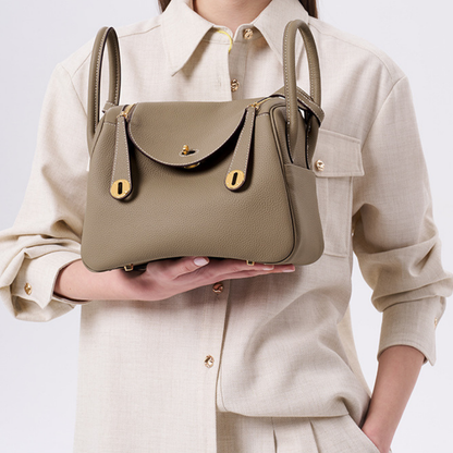 Sac à main en cuir bandoulière Élégance Cuir, modèle Nathalie, avec poignée et détails élégants, sur fond neutre.