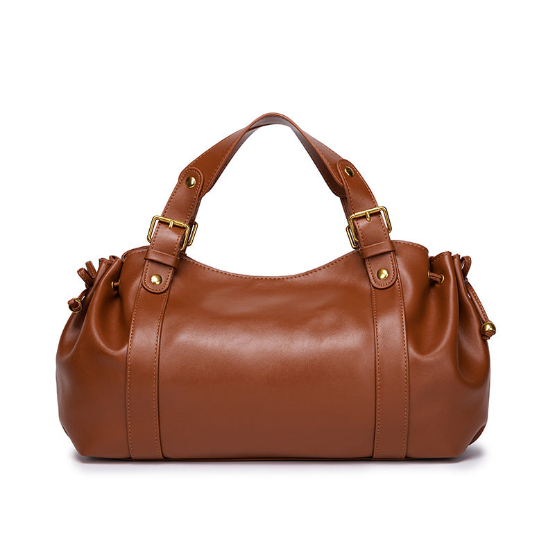 Sac à main vintage Élégance Cuir Noemi marron clair, en cuir, avec poignée et détails élégants, posé sur un fond neutre.