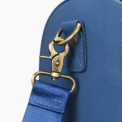 Détail attache bandoulière du sac de voyage en cuir bleu