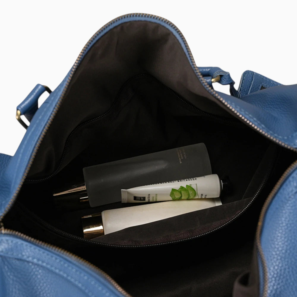 Intérieur du sac de voyage en cuir bleu avec objets de toilette