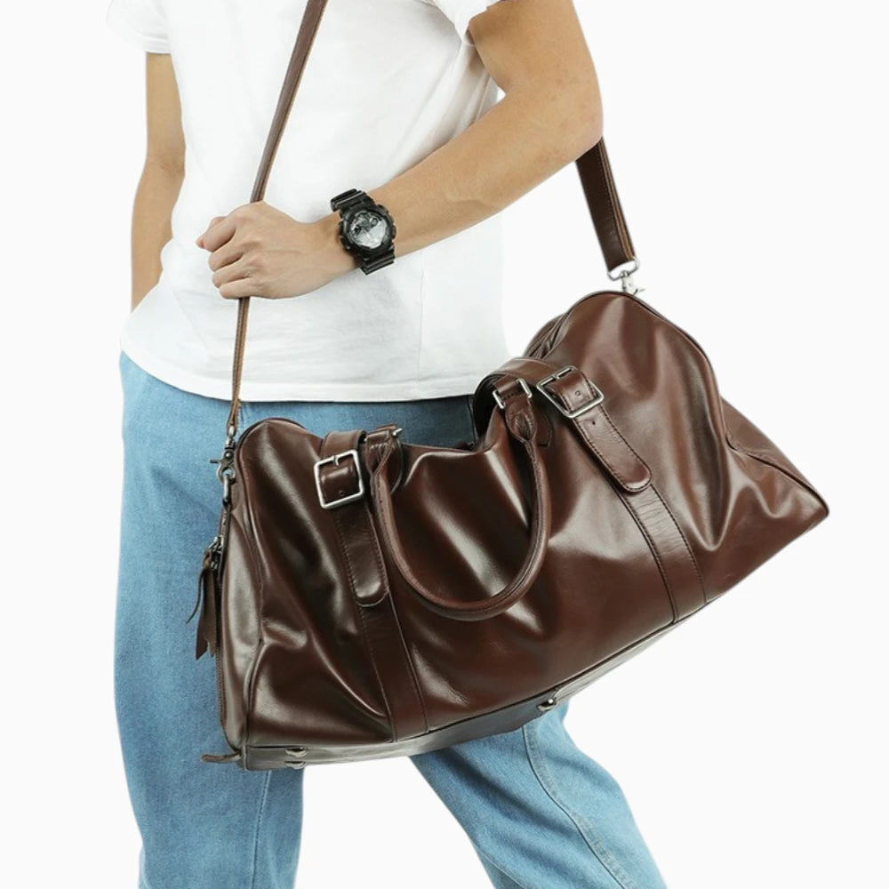 Sac de voyage en cuir marron porté à l’épaule