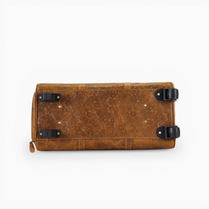 Dessous du sac de voyage en cuir marron avec roulettes