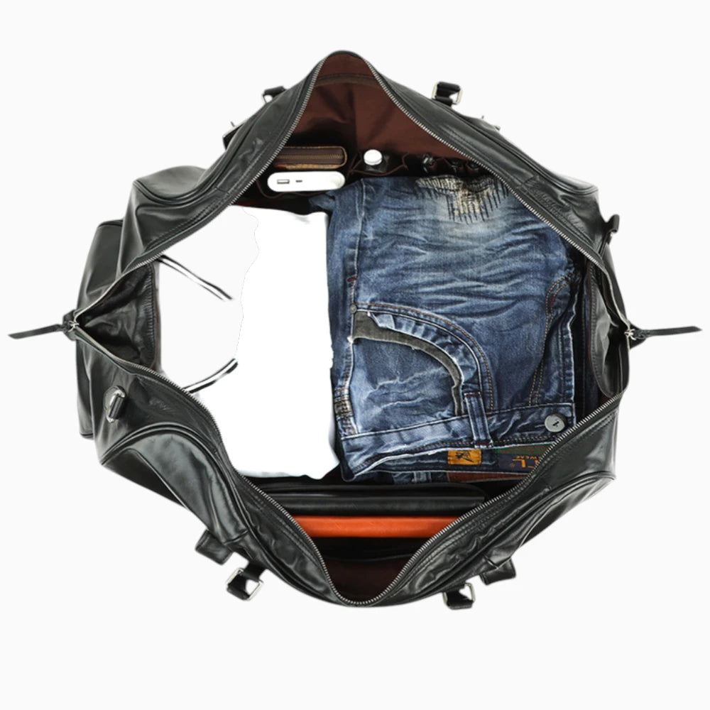 Intérieur du sac de voyage en cuir noir avec vêtements rangés