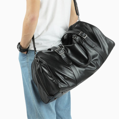 Sac de voyage en cuir noir porté à la main