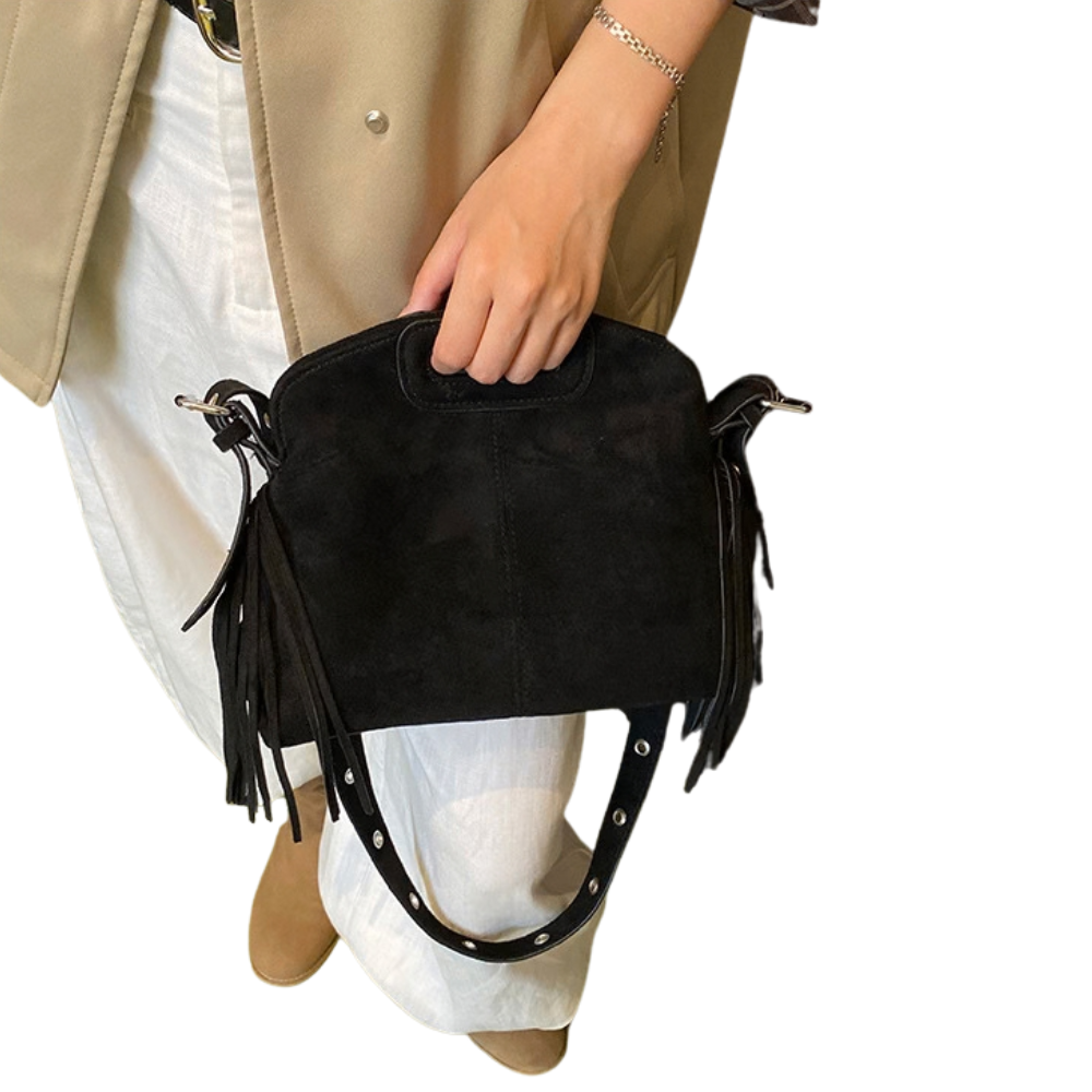 Sac Solène noir tenu à la main, bandoulière et franges visibles
